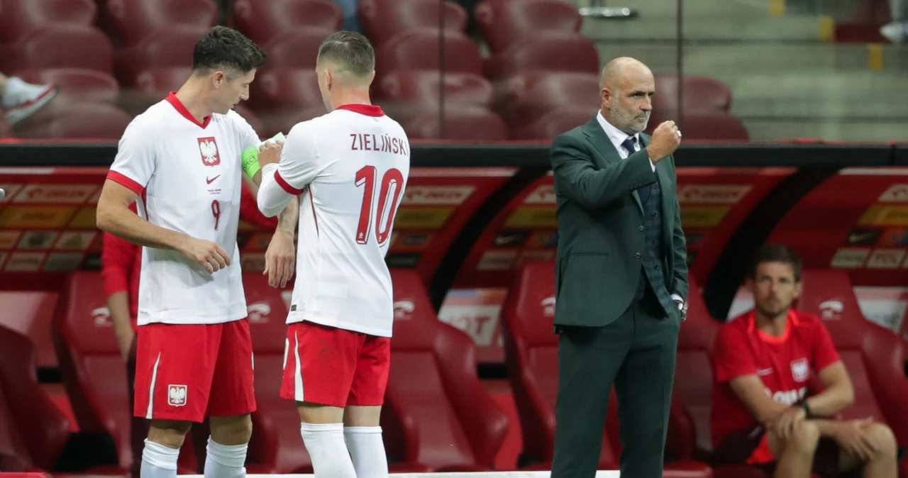 Piotr Zieliński zakłada opaskę kapitana Robertowi Lewandowskiemu. Z boku trener Michał Probierz