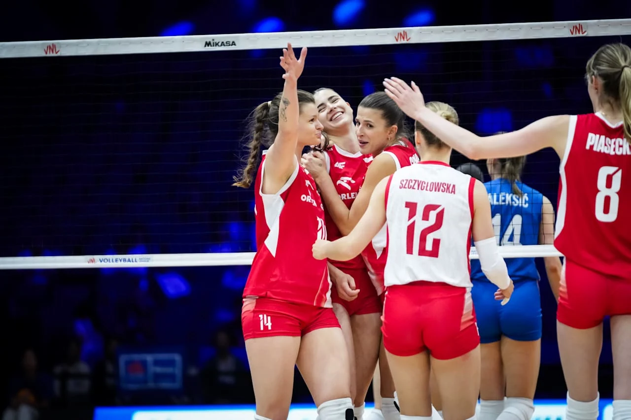 Zawodniczki drużyny siatkarskiej w czerwono-białych strojach świętują zdobycie punktu podczas meczu na hali sportowej.