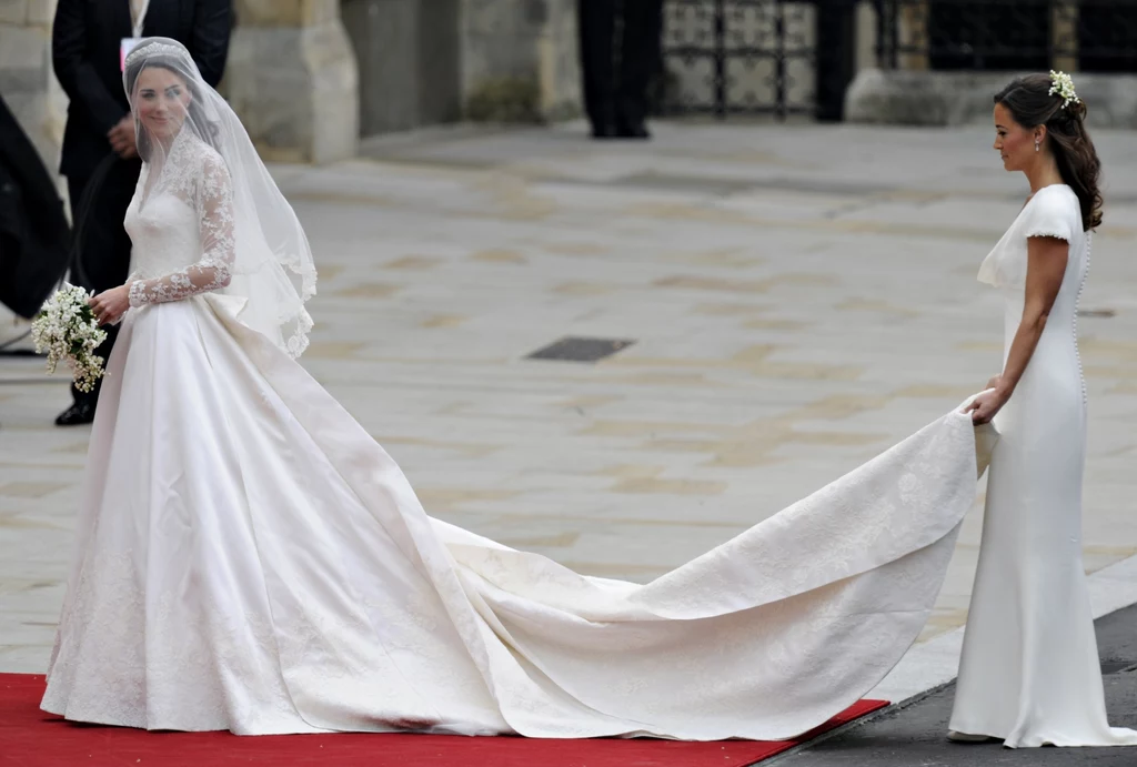 Kate Middleton w sukni zaprojektowanej przez Sarah Burton. Tren trzyma jej siostra, Pippa Kate Middleton w sukni zaprojektowanej przez Sarah Burton. Tren trzyma jej siostra, Pippa