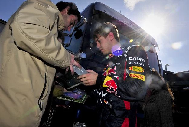 Sebastian Vettel (z prawej) rozdaje autografy