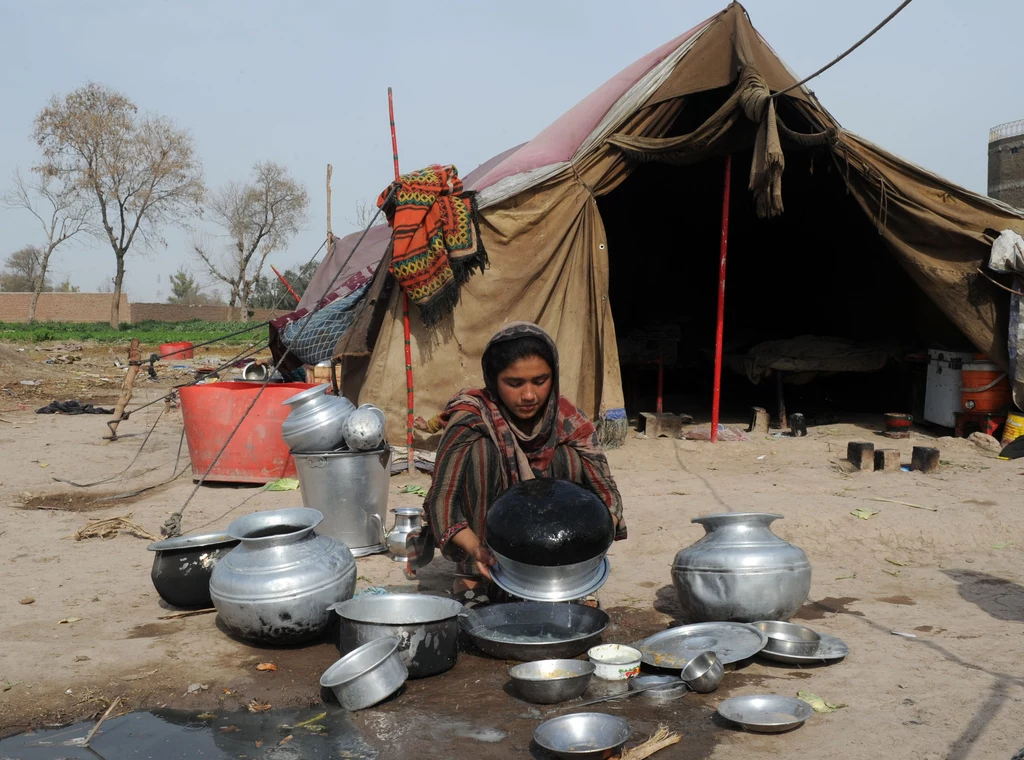 Pakistan. Kobieta z koczowniczego plemienia myje naczynia Pakistan. Kobieta z koczowniczego plemienia myje naczynia