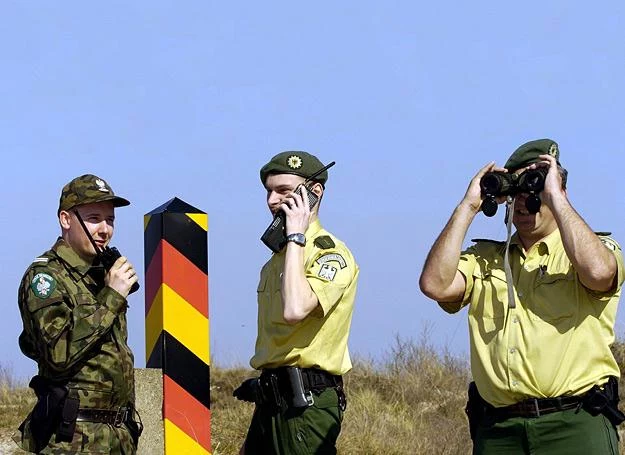 Polski i niemieccy strażnicy przy granicy państw przebiegającej w pobliżu Świnoujścia. Lipiec 2001 r