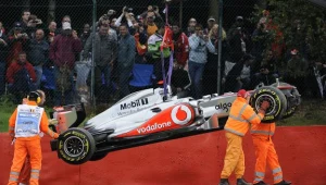 Służby porządkowe usuwają rozbity bolid Lewisa Hamiltona