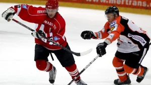 Tomasz Kulas z JKH GKS (P) walczy o krążek z Piotrem Sarnikiem z Cracovii fot: Andrzej Grygiel