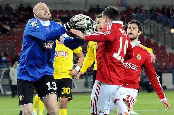Maciej Mielcarz, bramkarz Widzewa zabiera piłkę sprzed nosa Patryka Małeckiego.