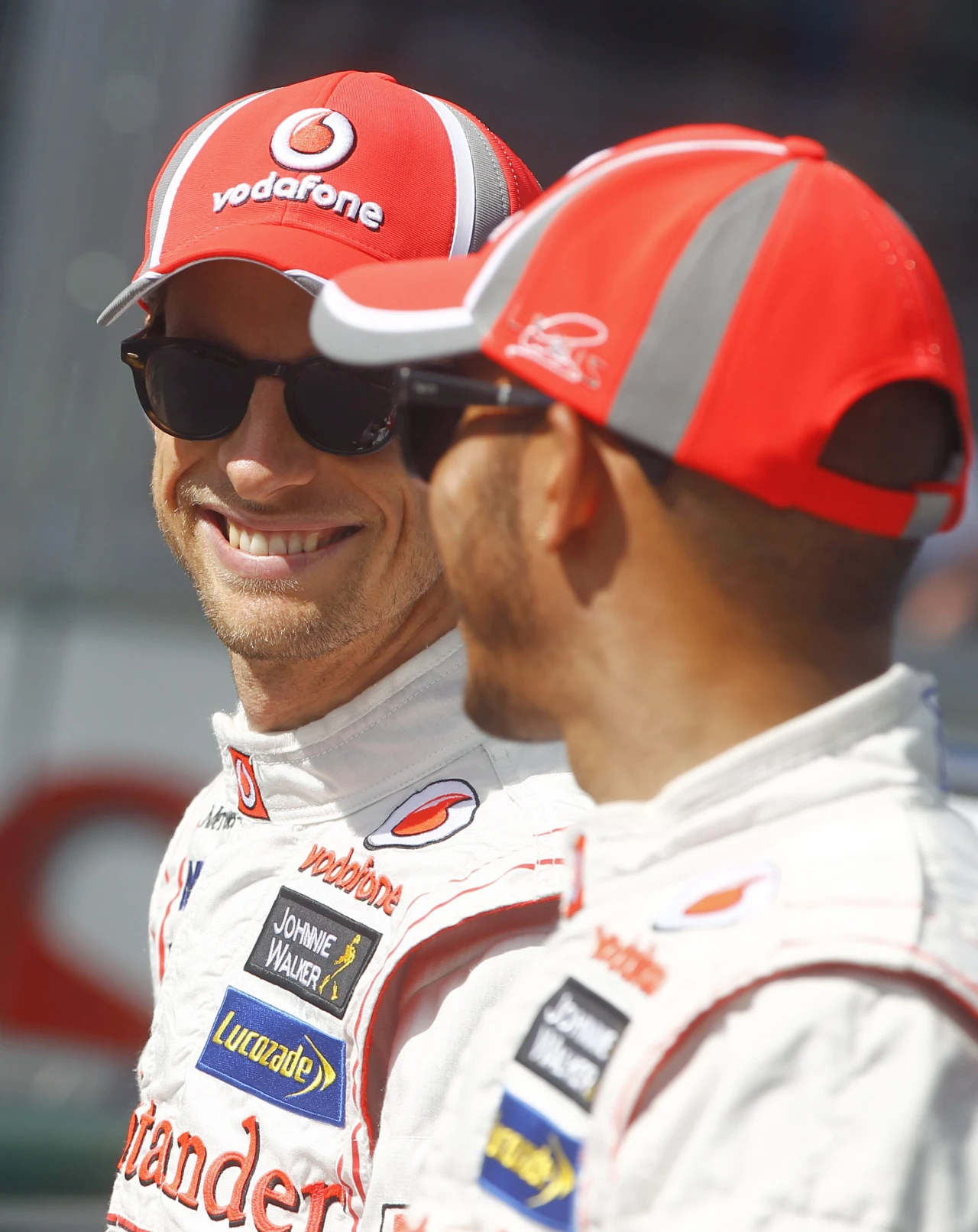 Jenson Button  rozmawia z kolegą z zespołu McLaren Mercedes Lewisem Hamiltonem