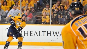 David Legwand z Nashville posyła krążek obok Henrika Zetterberga z Detroit.