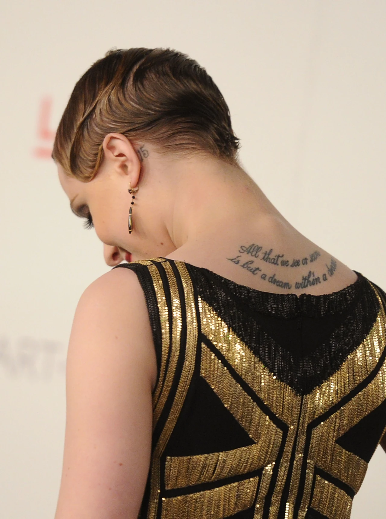 Na karku Evan Rachel Wood widnieje napis: All that we see or seem is but a dream within a dream Na karku Evan Rachel Wood widnieje napis: All that we see or seem is but a dream within a dream