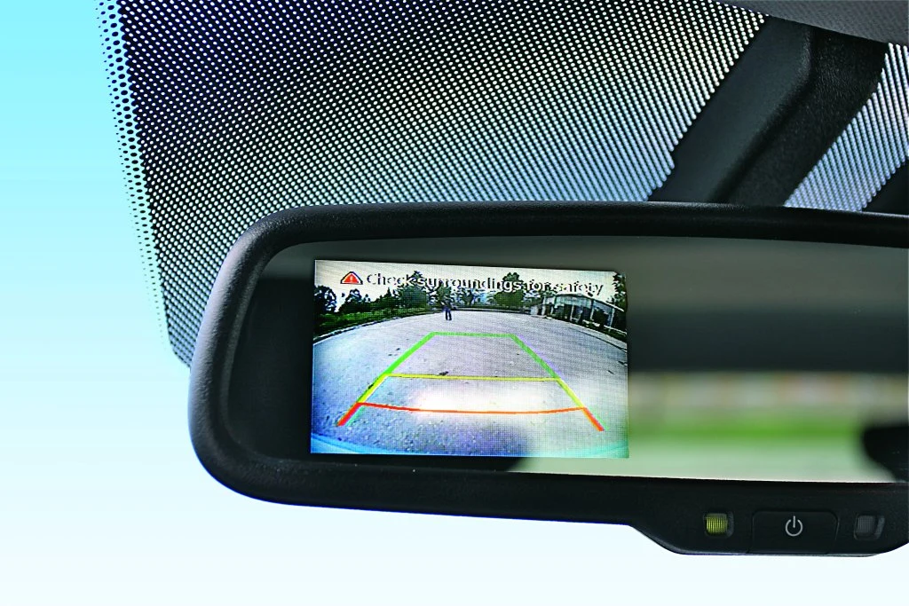 Obraz z kamery cofania wyświetlany jest w lusterku wstecznym. Obiektyw znajduje się na pokrywie bagażnika.