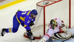 Kamil Kosowski, bramkarz hokejowej reprezentacji Polski blokuje strzał Konstantina Kasjanczuka