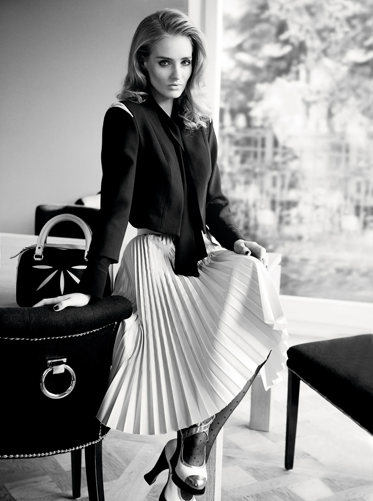 Dopasowana góra plus spódnica na planie koła to niezawodny zestaw wyjściowy. Jednak w tym przypadku atutów jest więcej. Na czarną jedwabną koszulę narzucono bolerko o wyrazistej konstrukcji. Takie okrycie świetnie kamufluje zbyt mały lub zbyt duży biust, eksponuje smukłą talię. Plisowana spódnica uszyta jest ze sztywnego jedwabiu, a to znaczy, że będzie trzymać formę przez cały wieczór. A pantofle na pięknie wyprofilowanym słupku są tak samo ładne, jak wygodne.