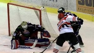 Bramkarz Ciarko PBS Bank Sanok Przemysław Odrobny (L) broni strzał Petra Valczaka z Comarch Cracovii