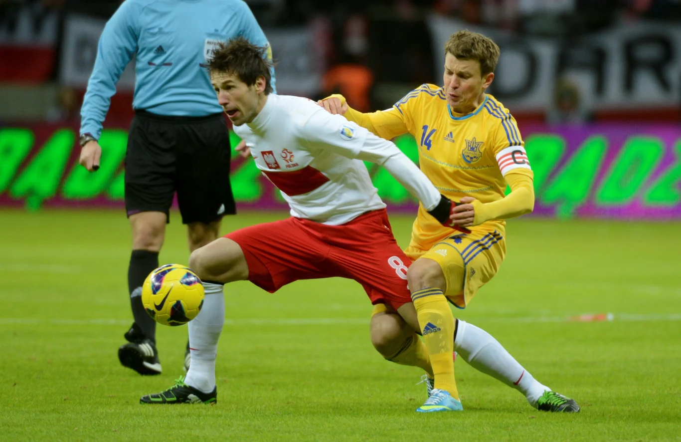 Ukrainiec Rusłan Rotań (P) walczy o piłkę z Polakiem Grzegorzem Krychowiakiem