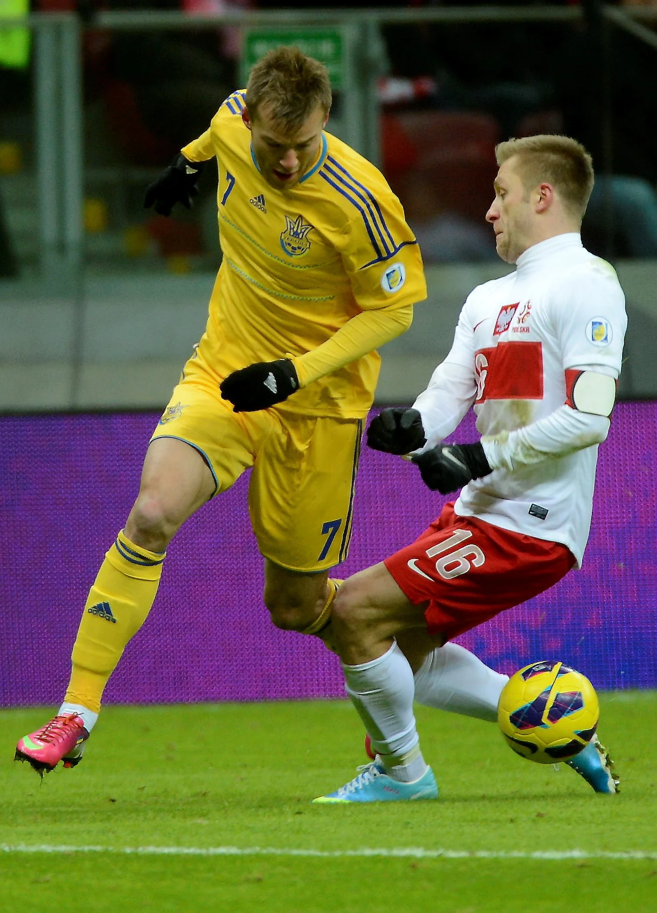 Polak Jakub Błaszczykowski (P) walczy o piłkę z Ukraińcem Andrijem Jarmołenką