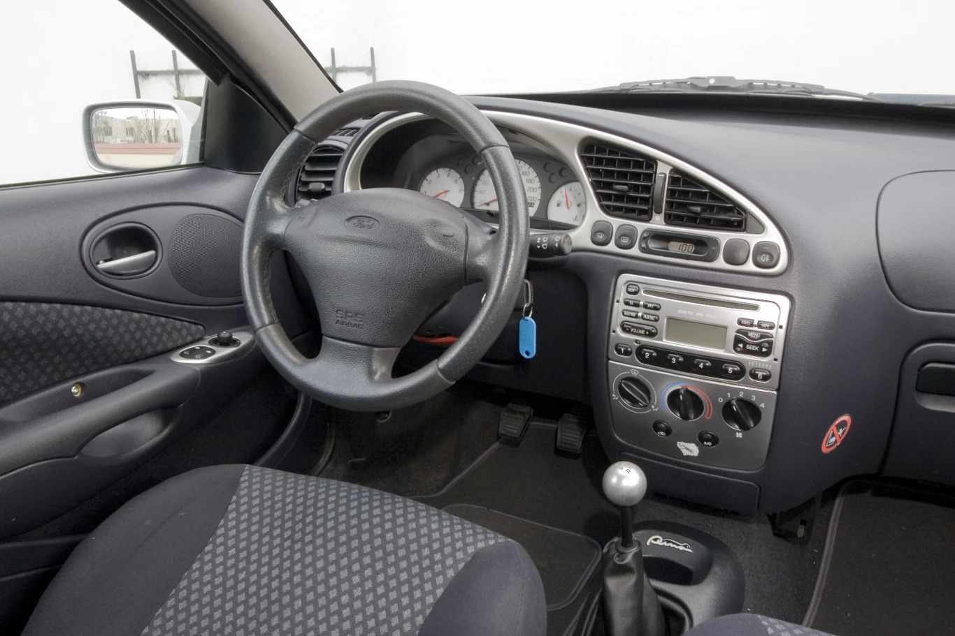 Prawie jak z Fiesty, ale nie do końca. Wyróżnia się metalowa gałka biegów i takie same wykończenia. Większość aut ma klimatyzację