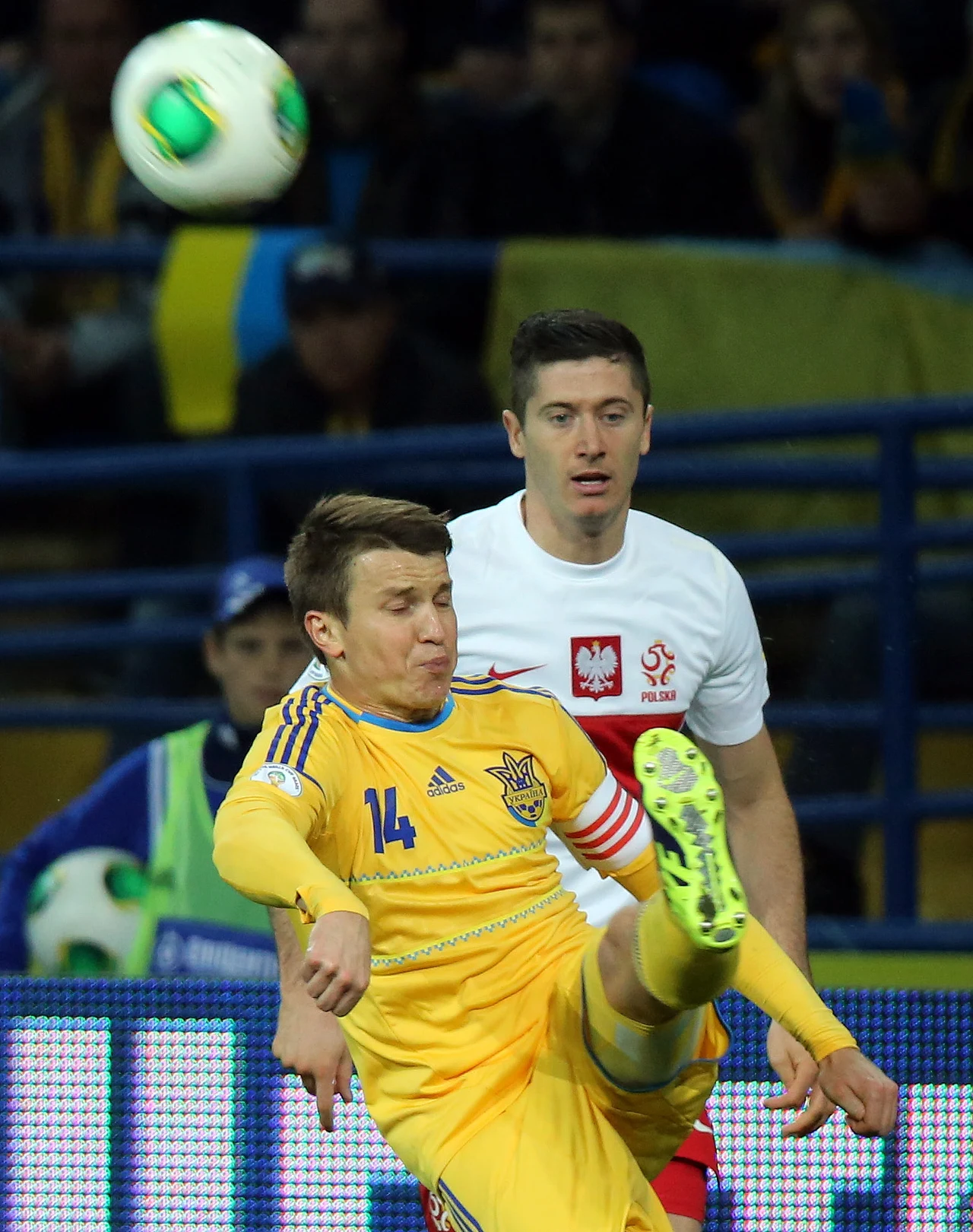  Piłkę wykopuje Ukrainiec Rusłan Rotań (L) przed graczem reprezentacji Polski Robertem Lewandowskim 