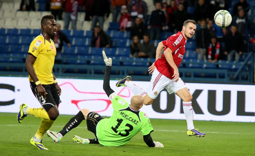  Piłkarz Wisły Kraków Paweł Brożek (P) pokonuje bramkarza Widzewa Łódź Macieja Mielcarza 