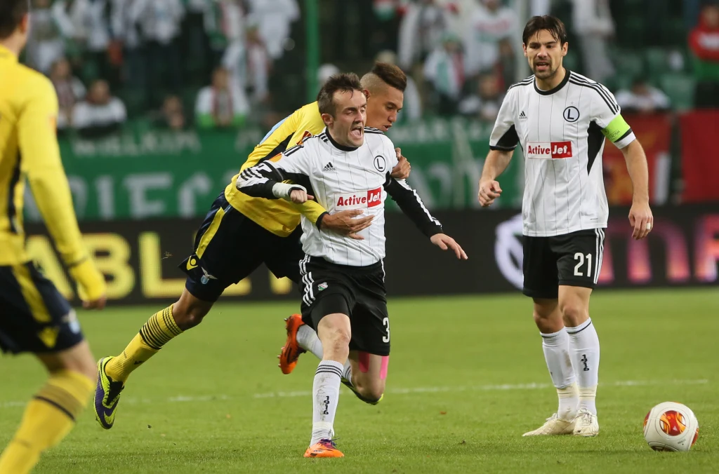 Miroslav Radović (C) ze stolecznej Legii przytrzymywany przez interweniującego z tyłu Brayana Perea Miroslav Radović (C) ze stolecznej Legii przytrzymywany przez interweniującego z tyłu Brayana Perea