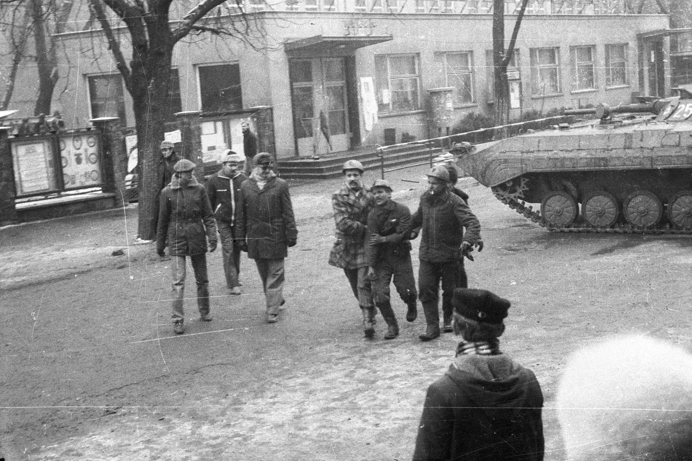 Górnicy wyprowadzają rannego kolegę z terenu kopalni, Katowice, 16.12.1981