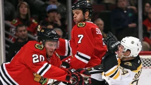 Carl Soderberg z Boston Bruins w starciu z Brandonem Saadem i Brentem Seabrookiem z Chicago Blackhawks