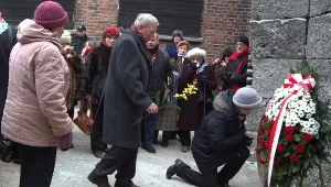 Byli więźniowie obozu składają kwiaty pod Ścianą Śmierci w byłym obozie Auschwitz I