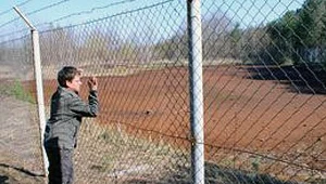 Za tym płotem są wielkie rowy z brunatnym bagnem