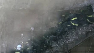 Strażacy dogaszają pożar, w kórym wielu ludzi straciło cały swój dobytek.