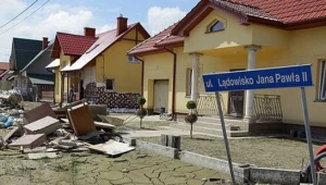 Przed domami zalegają sterty zniszczonych mebli, ubrań, książek