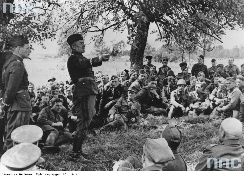 Gen. Karol Świerczewski stoi i przemawia do żołnierzy. To zdjęcie znajdziesz w zbiorach NAC <a href="http://audiovis.nac.gov.pl/obraz/133377/7c1f0350d0e2bb78ca10049e64af1cc5/" target="_blank">TUTAJ</a>