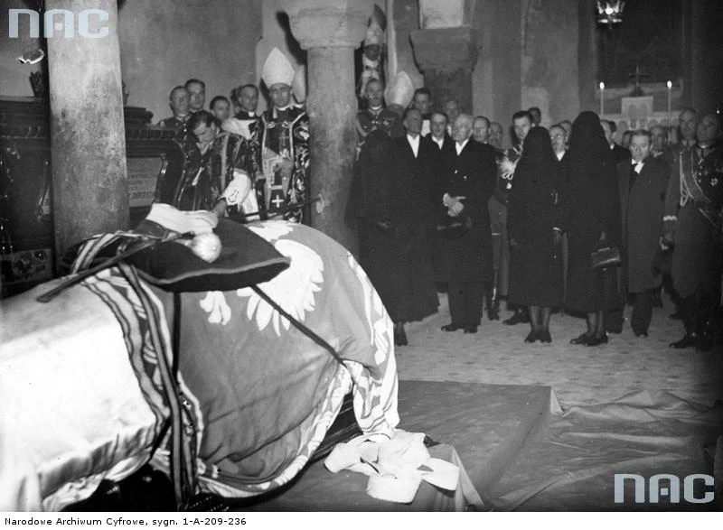Kraków, 18.05.1935, trumna w krypcie św. Leonarda na Wawelu. Widoczni m.in. Aleksandra Piłsudska (przy kolumnie), obok prezydent Ignacy Mościcki, szef Kancelarii Cywilnej Prezydenta RP Stanisław Świeżawski, adiutanci prezydenta RP kpt. Zygmuny Gużewski i kpt. Józef Hartman