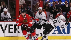 Mike Richards (Los Angeles Kings) pada na lód po starciu z Jonathanem Toewsem z Chicago Blackhawks 
