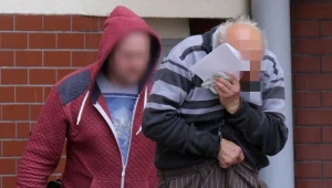 59-letni Jan A. (P) prowadzony przez policjanta. 