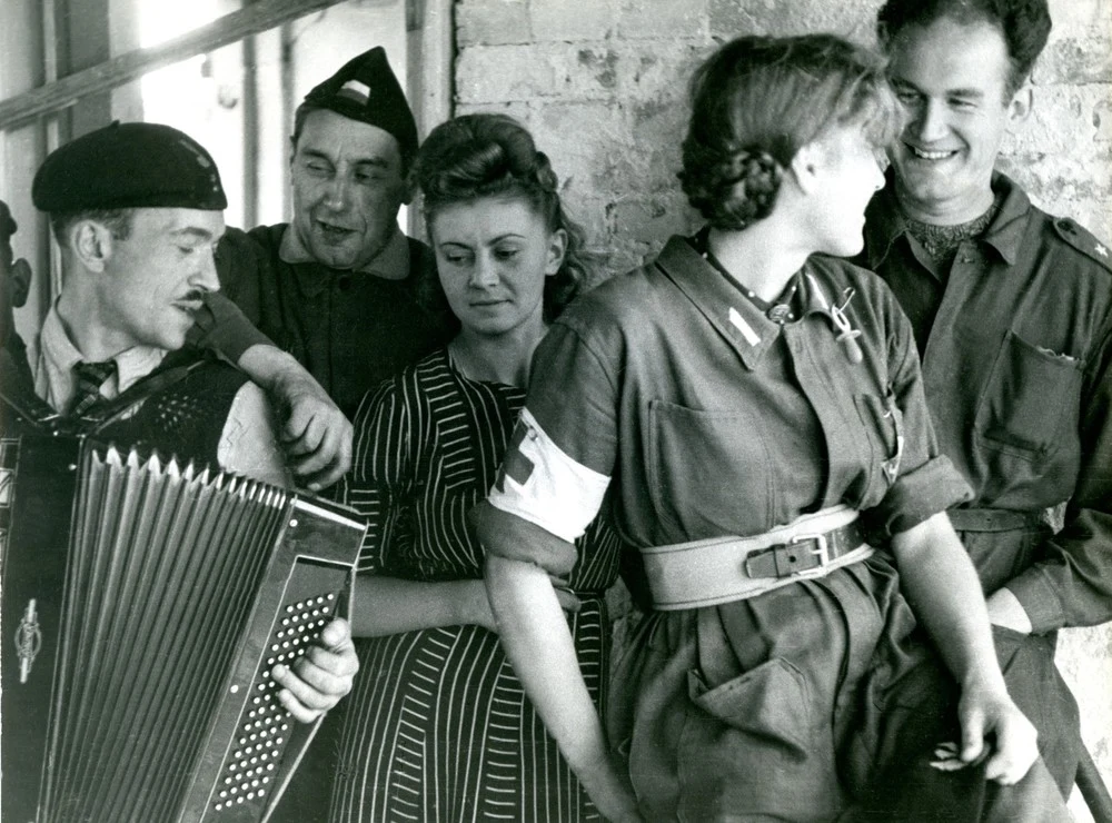 Powstanie Warszawskie, Mokotów, ulica Malczewskiego, wrzesień 1944. Pierwszy z prawej Jan Markowski (por. Krzysztof), znany pianista i kompozytor, autor "Marszu Mokotowa"; obok niego sanitariuszka "Malgorzatka", czyli Janina Zaleska, studentka SGGW; z lewej strony z akordeonem Wacław Żdżarski.