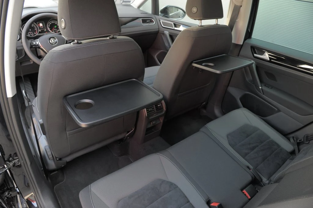 Jak przystało na minivana – w oparciach przednich foteli zamontowano dwa składane stoliki. Jak przystało na minivana – w oparciach przednich foteli zamontowano dwa składane stoliki.