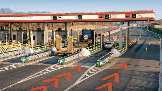 Pomarańczowe oznakowanie na jezdni, informuje o zbliżaniu się do bramki obsługującej tylko płatność elektroniczną. Pomarańczowe oznakowanie na jezdni, informuje o zbliżaniu się do bramki obsługującej tylko płatność elektroniczną.