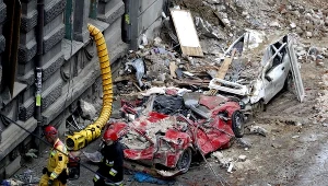 Strażacy obok wraków samochodów zmiażdżonych przez gruz z kamienicy w Katowicach