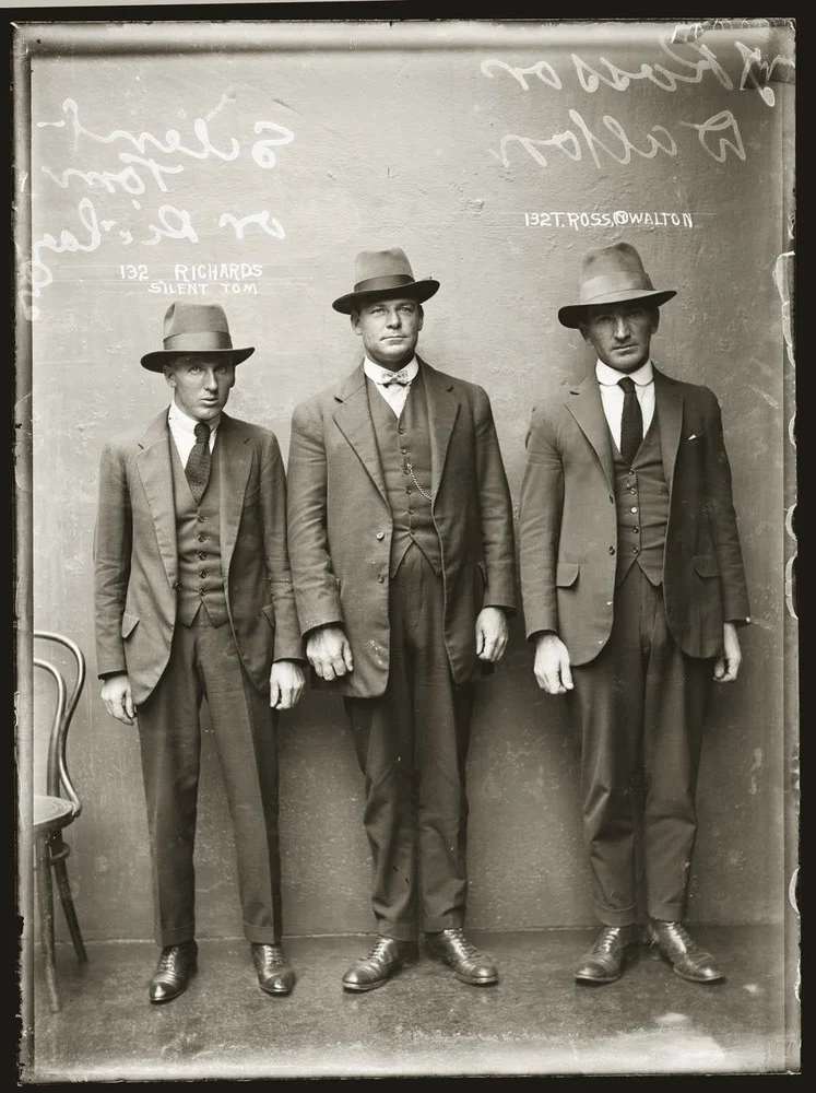 Zdjęcie przedstawia "Silent Toma" Richardsa i T. Rossa, alias T. Waltona i nieznanego gangstera, 12 kwietnia 1920. Zapewne Central Police Station, Sydney. Cała trójka zajmowała się przemytem.