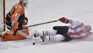 Atakujący Dennis McCauley (P) z miejscowej Comarch Cracovii nie daje rady pokonać bramkarza JKH GKS Jastrzębie Przemysława Odrobnego 