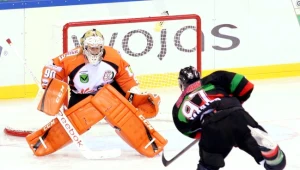 Maksim Kartoszkin z GKS-u Tychy strzela na bramkę JKH GKS Jastrzębie w której stoi Przemysław Odrobny