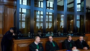 Oskarżeni (za szybą) o udział w zorganizowanej grupie przestępczej zajmującej się sutenerstwem oraz ich adwokaci