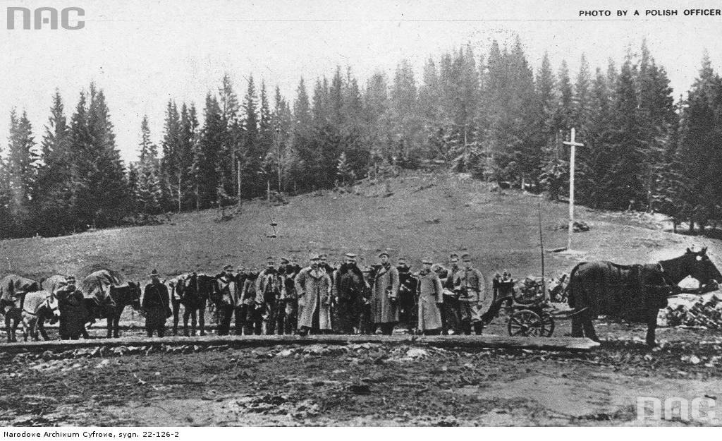 II Brygada Legionów podczas walk w Karpatach. Oddział legionistów. W tle krzyż postawiony przez polskich żołnierzy na granicy Galicji z Węgrami na przełęczy Pantyrowej, 1914