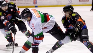 Hokeista GKS Tychy Adam Bagiński (C) walczy o krążek z Markiem Strzyżowskim (L) i Rafałem Ćwikłą (P) z Ciarko PBS Bank Sanok 