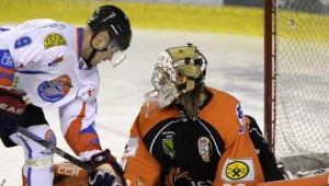 Petr Sinagl (L) z Ciarko PBS Bank atakuje bramkę JKH GKS Jastrzębie, bronioną przez Przemysława Odrobnego