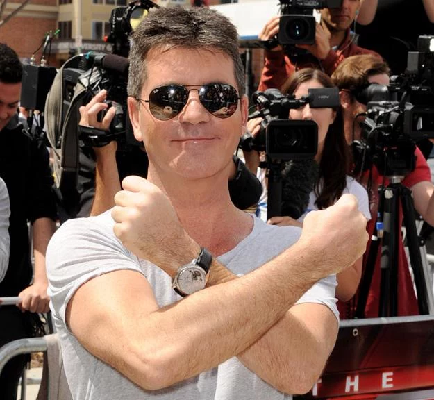 Simon Cowell pokazuje znak "X Factor" - fot. Kevin Winter