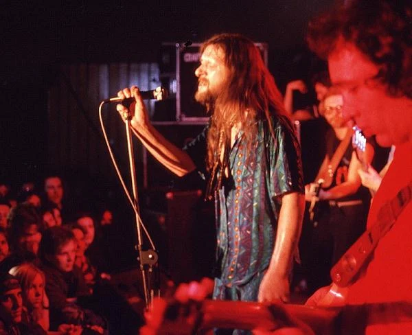 "Ten niesforny, niesumienny, nieobliczalny, uciążliwy w studiu wokalista przemieniał się na scenie - niezależnie od swego stanu - we władcę absolutnego tłumu. W kapłana odprawiającego rockowe msze. Oczywiście jeśli dotarł na koncert - bo to też nie było takie pewne. Jeśli się nie spóźnił, jeśli gdzieś się nie zapodział... Ale jeśli się nie spóźnił ani nie zapodział - wystarczyło, że rzucił to swoje 'Sie macie ludzie!' i już miał tych ludzi u stóp. Właśnie na scenie jeszcze lepiej pokazywał, jakiego formatu był artystą. Jaką miał władzę nad słuchaczami. Jaką siłę miały jego naturalność i autentyzm. Po prostu hipnotyczną... Nie musiał uciekać się do grepsów, układanej choreografii. Wystarczyło, że był sobą. Że miał te swoje dżinsy, trampki albo kowbojki, ten swój kapelusz na głowie" - tak o wokaliście pisał Jan Skaradziński w biografii "Rysiek". Koncert Dżemu w Ośrodku Kultury Arsus, Warszawa, 1993 r.