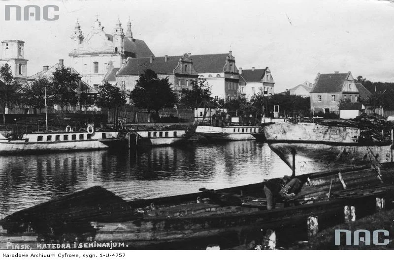 Pińsk - fragment miasta z widocznym kościołem Wniebowzięcia Najświętszej Maryi Panny i rzeką, po której pływają barki