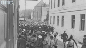 Policja rozprasza formujący się pochód uczestników zjazdu Obozu Wielkiej Polski. Na pierwszym planie widoczni umundurowani członkowie ugrupowania w piaskowych koszulach, granatowych spodniach i beretach