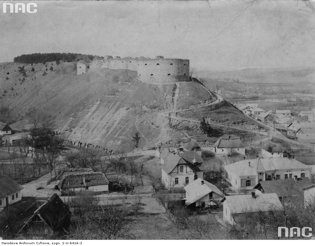 Trembowla - widok na ruiny zamku. Widoczne zewnętrzne mury oraz wały ziemne. U podnóża wzgórza zamkowego zabudowania miasta