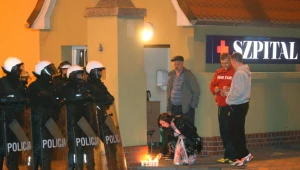 Kobieta zapala znicz przed szpitalem w Knurowie