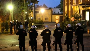 Patrolujący miasto z góry śmigłowiec i wzmożone siły policji w pobliżu miejscowego komisariatu są widoczne wieczorem w Knurowie